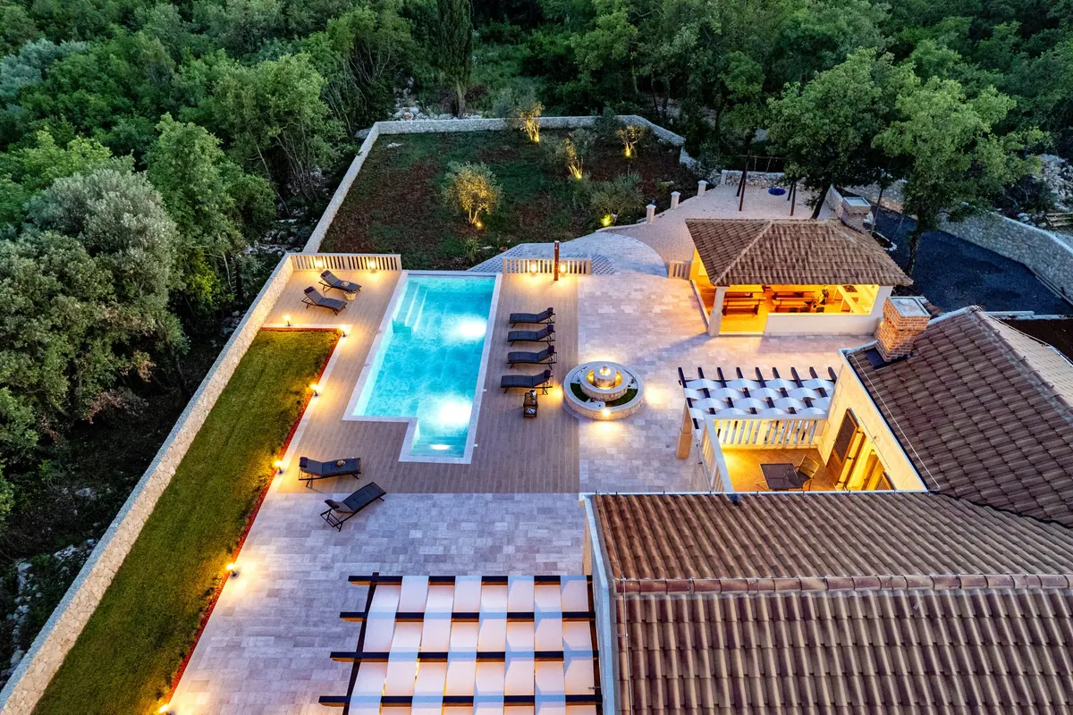 The estate from above at night, pool and garden lit