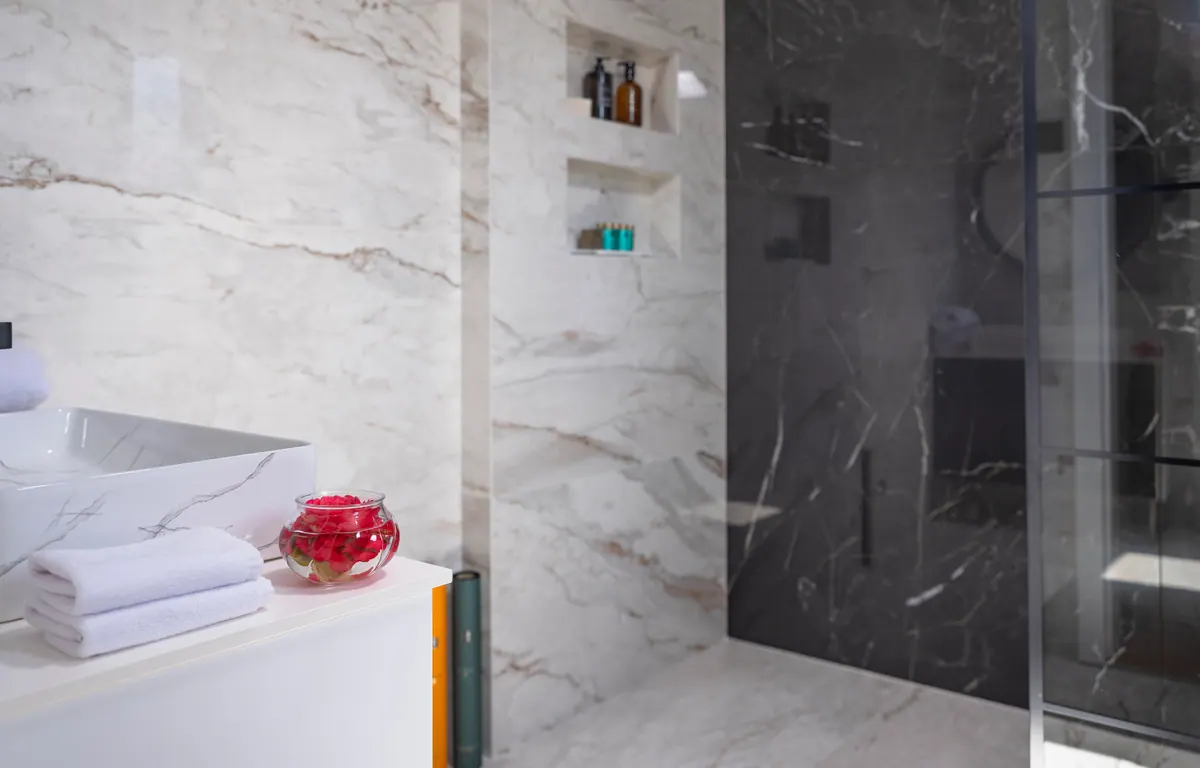 A marble shower with a glass screen