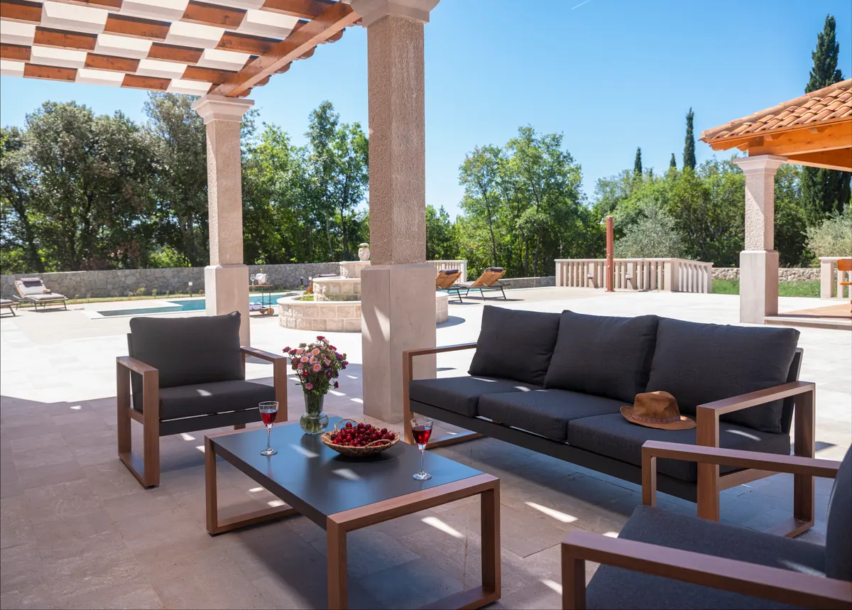 The covered terrace lounge with a view of the pool