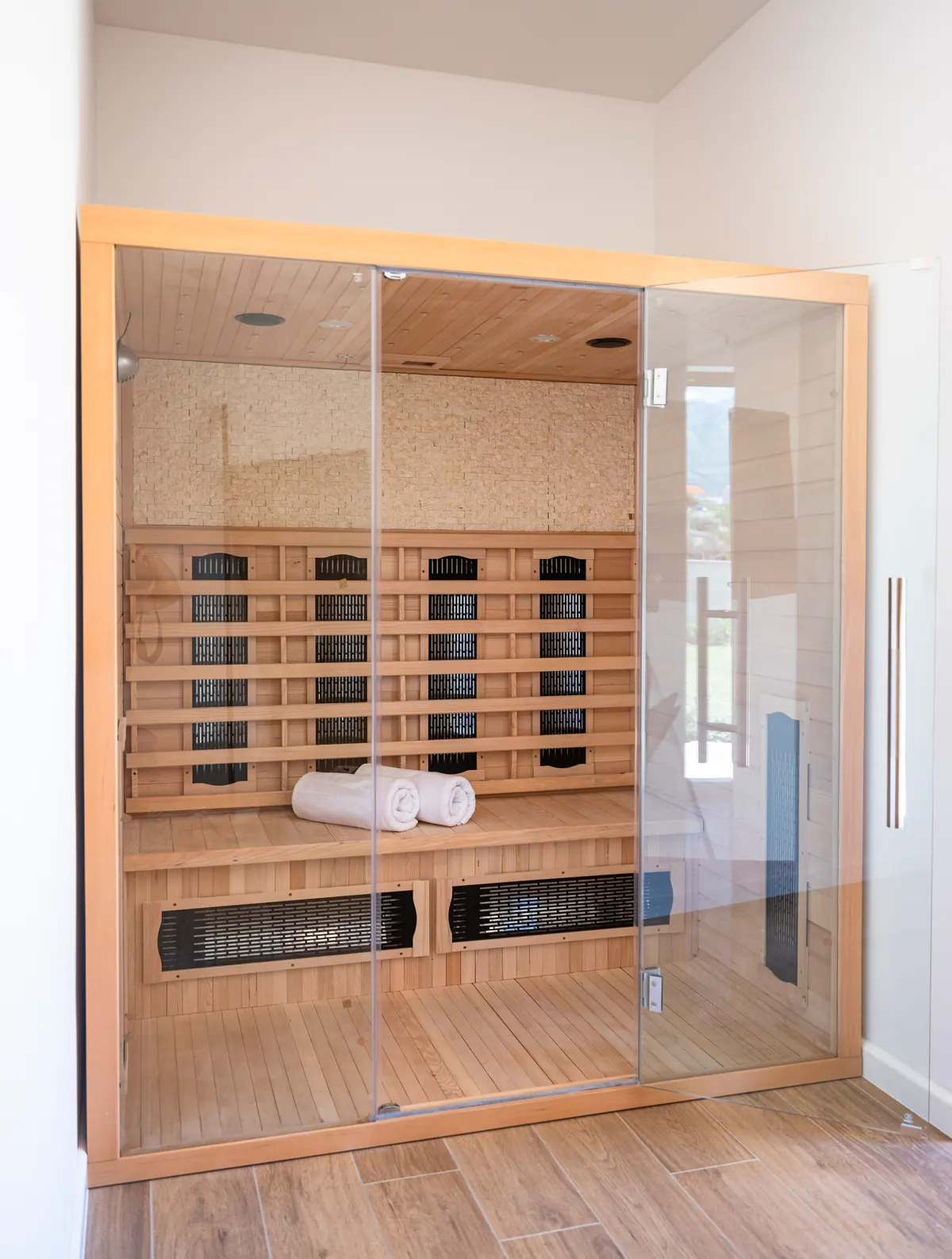 The private sauna cabin with glass door and wooden benches
